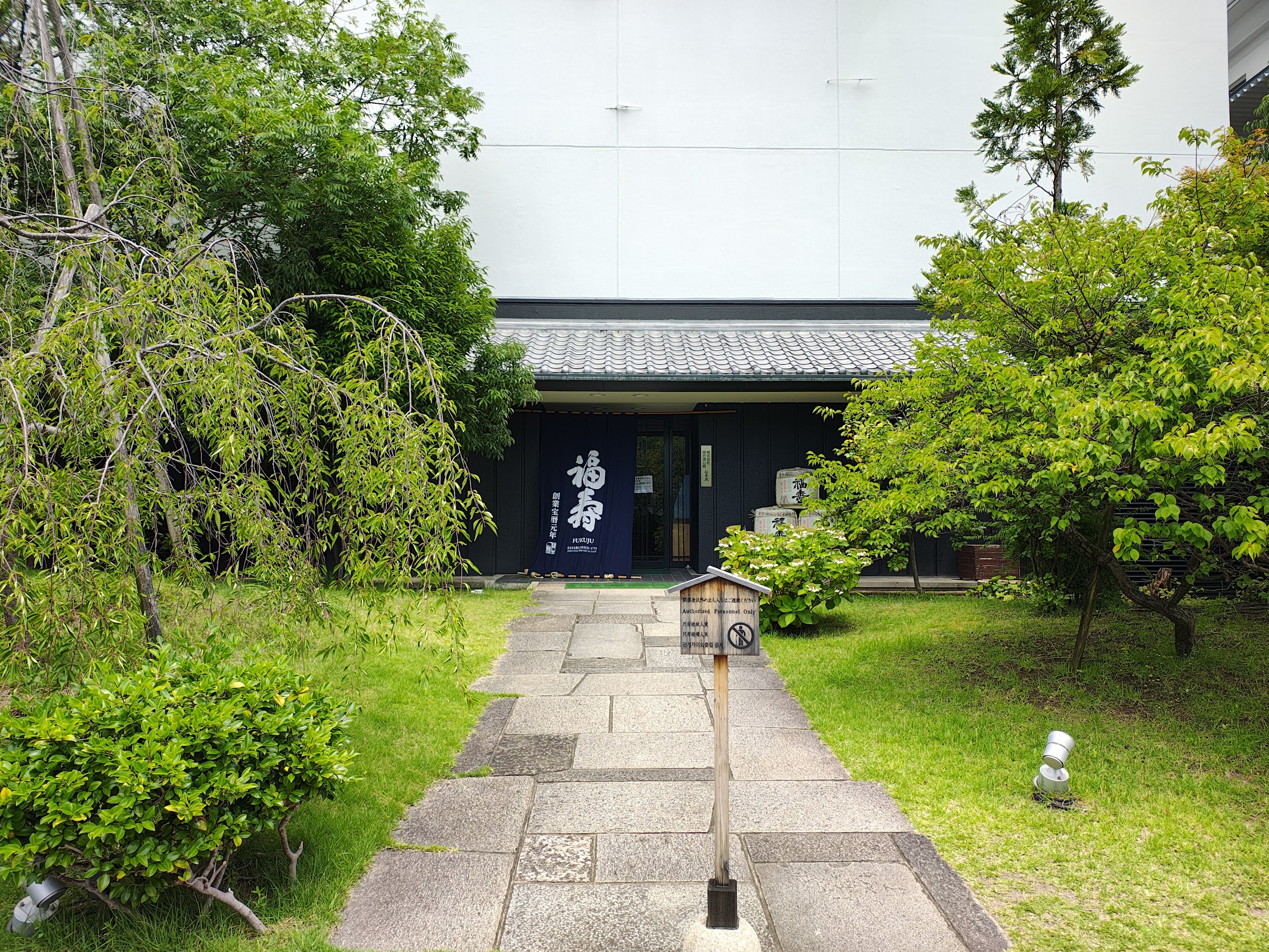 緑の庭と石畳の先に見える神戸酒心館の福寿蔵